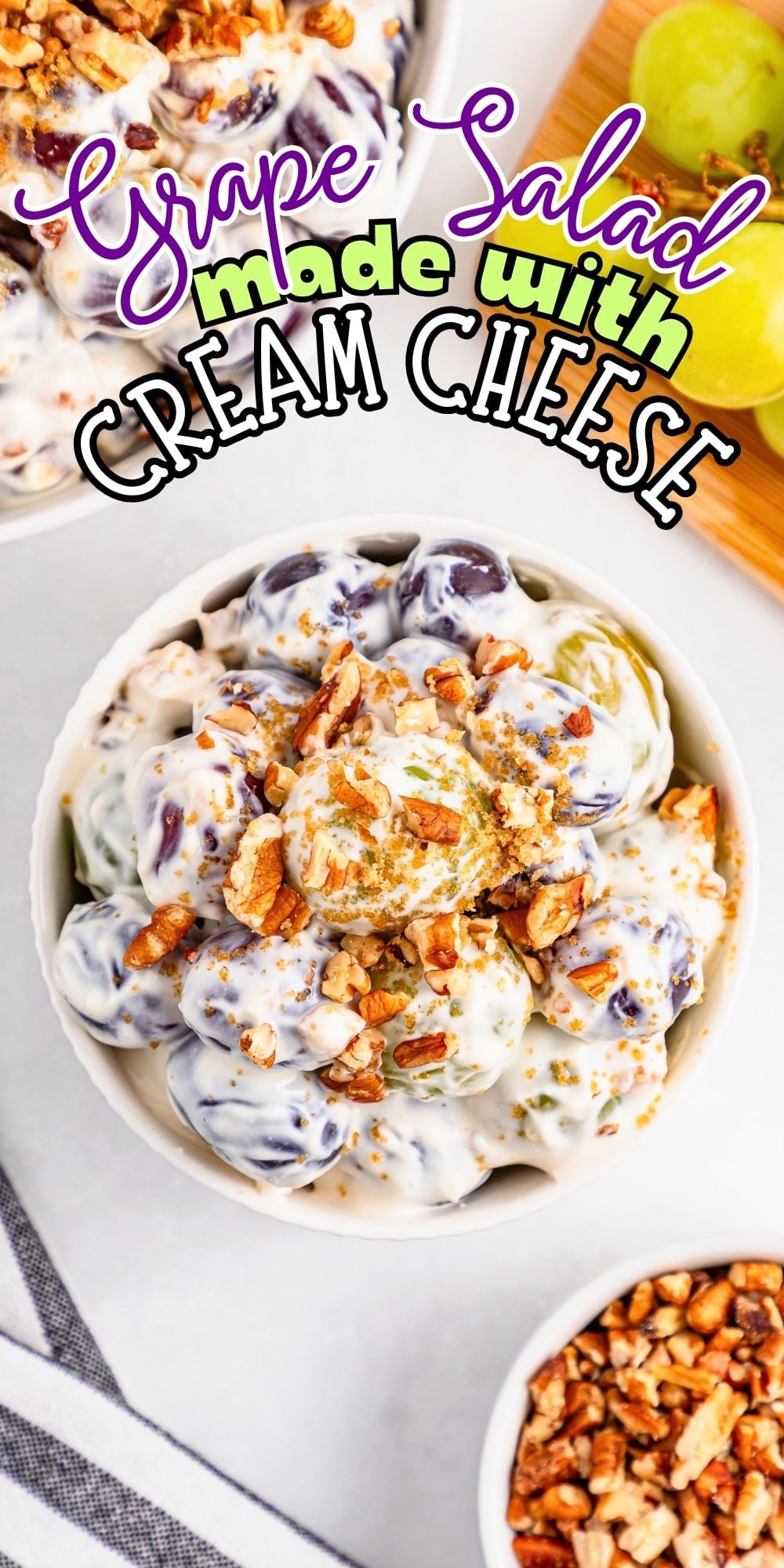 Bowl of grape salad with cream cheese, topped with chopped pecans.