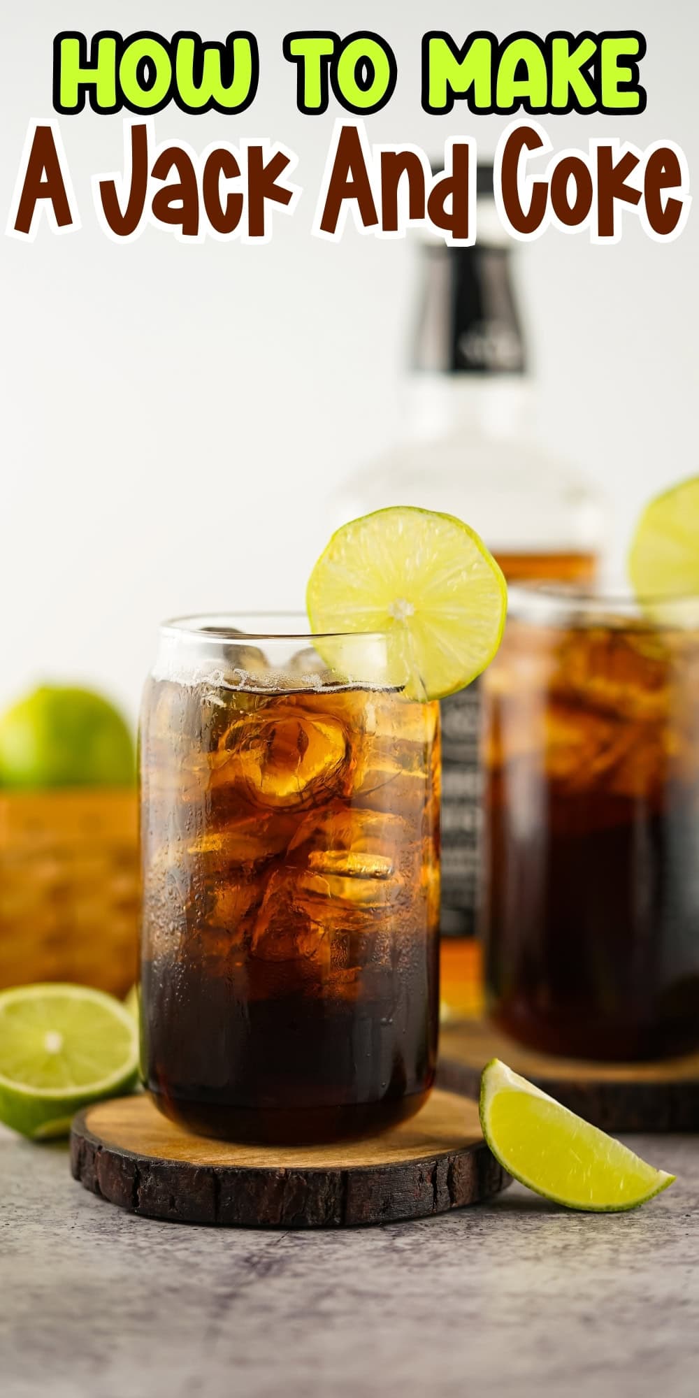 A Jack and Coke cocktail in a glass with ice and a lime wedge.