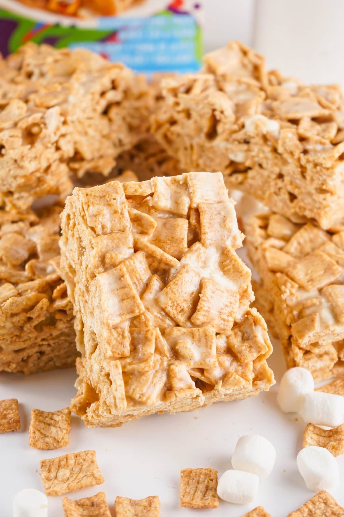 Cinnamon Toast Crunch cereal bars with marshmallows on a white surface.