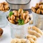 Three metal buckets filled with boiled peanuts, garnished with parsley.
