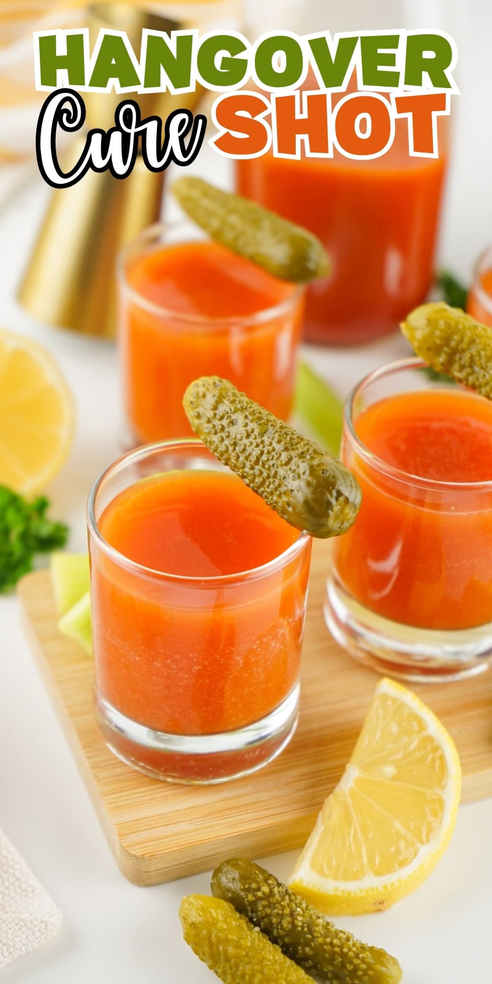 Four glasses of red juice with pickles and lemon slices.