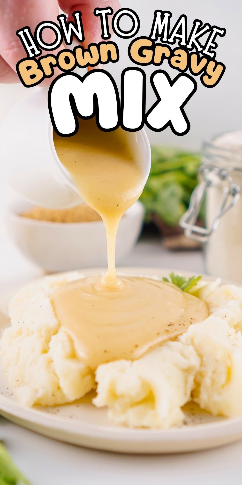 A bowl of gravy being poured over mashed potatoes.