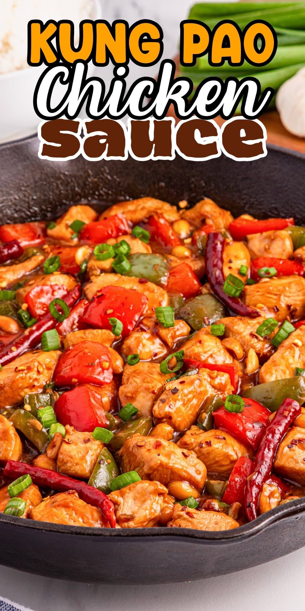 Kung pao chicken with vegetables and sauce in a cast iron skillet.