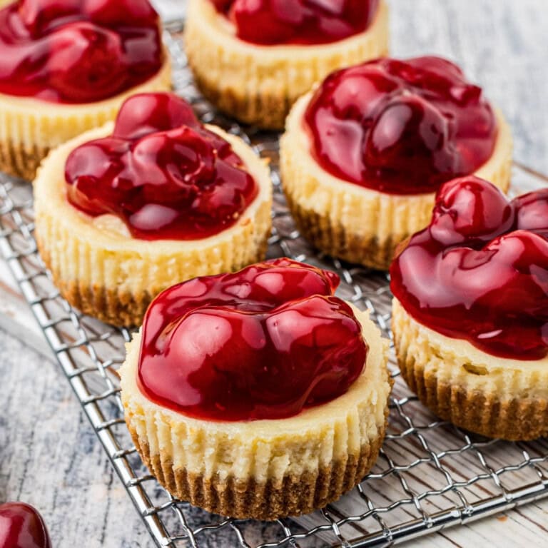 Mini cheesecakes from easy cheesecake recipes, topped with glossy cherry pie filling.