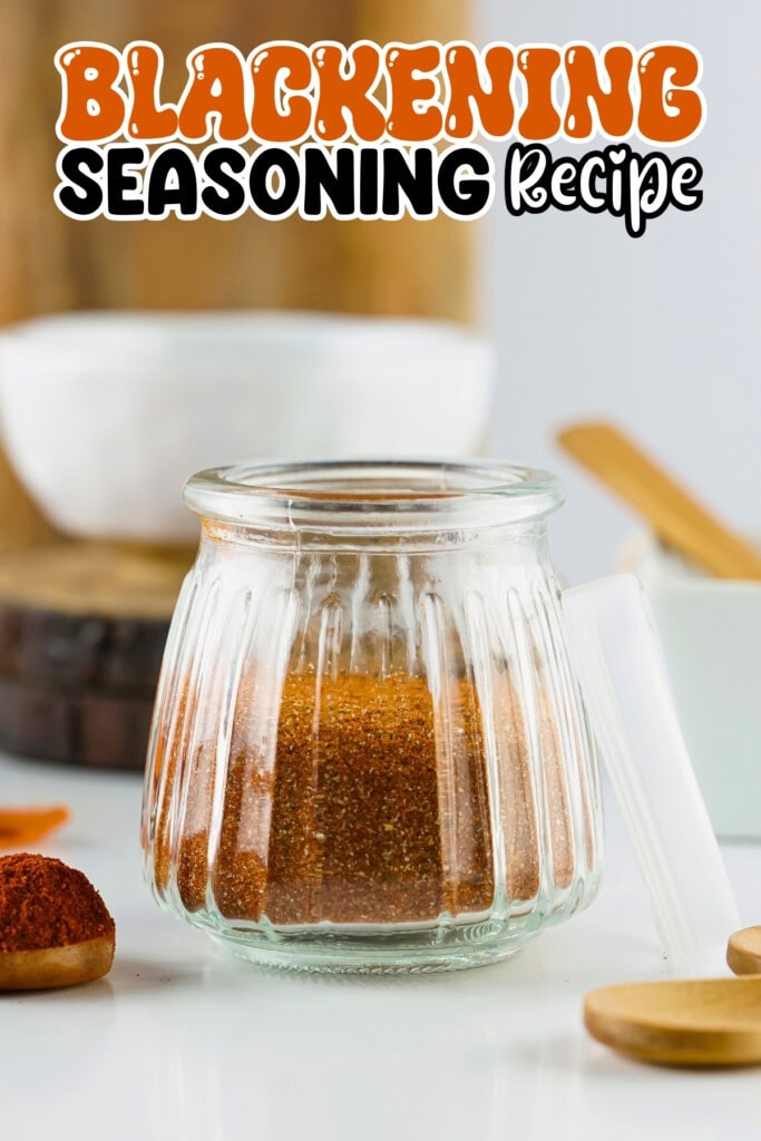 Glass jar filled with blackening seasoning; bowls and spoons in the background.