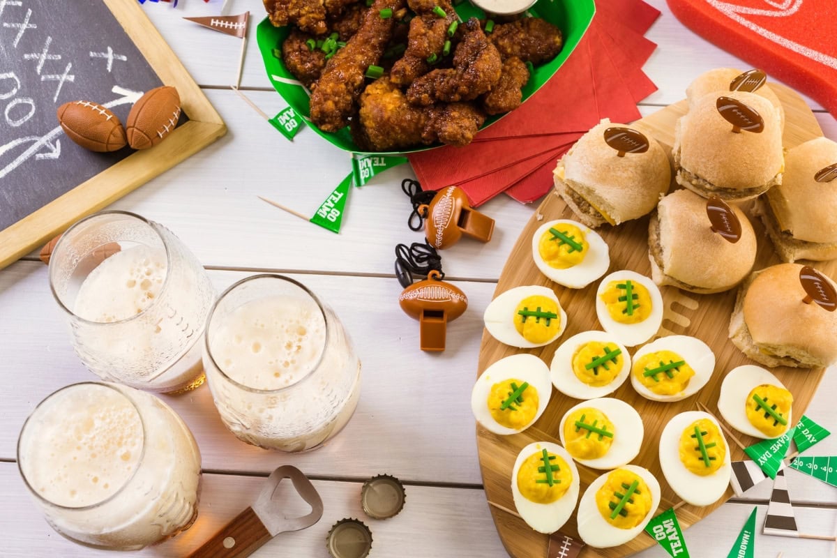 Football-themed snacks with deviled eggs, sliders, beer, and chicken wings.