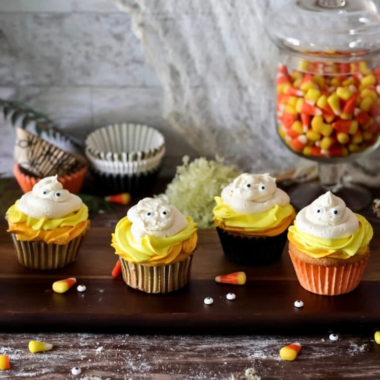 Five cupcakes with yellow frosting—fun Halloween cake decorating ideas for parties.