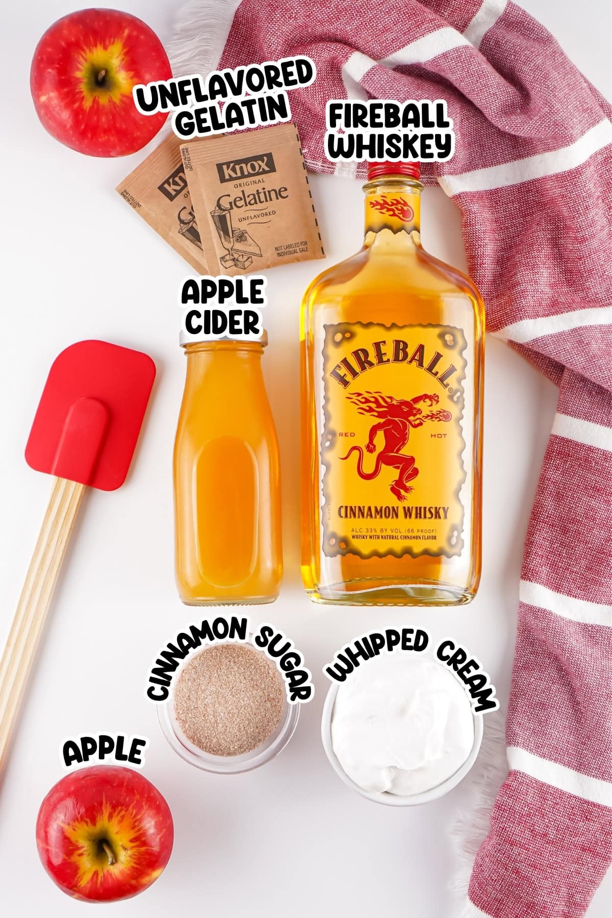 Apple, gelatin, cider, whiskey, sugar, and whipped cream on a white surface.