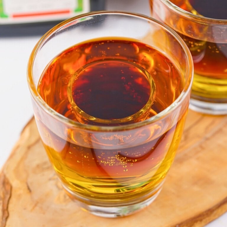A glass showing a classic Jager bomb recipe with a shot glass nested inside.