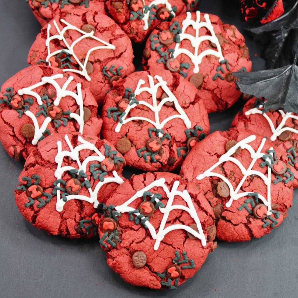 Red cookies with spiderweb icing, perfect for spooky Halloween potluck ideas.
