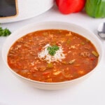 A bowl of Crockpot Stuffed Pepper Soup with rice, beef, and parsley garnish.