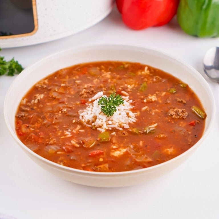 A bowl of Crockpot Stuffed Pepper Soup with rice, beef, and parsley garnish.
