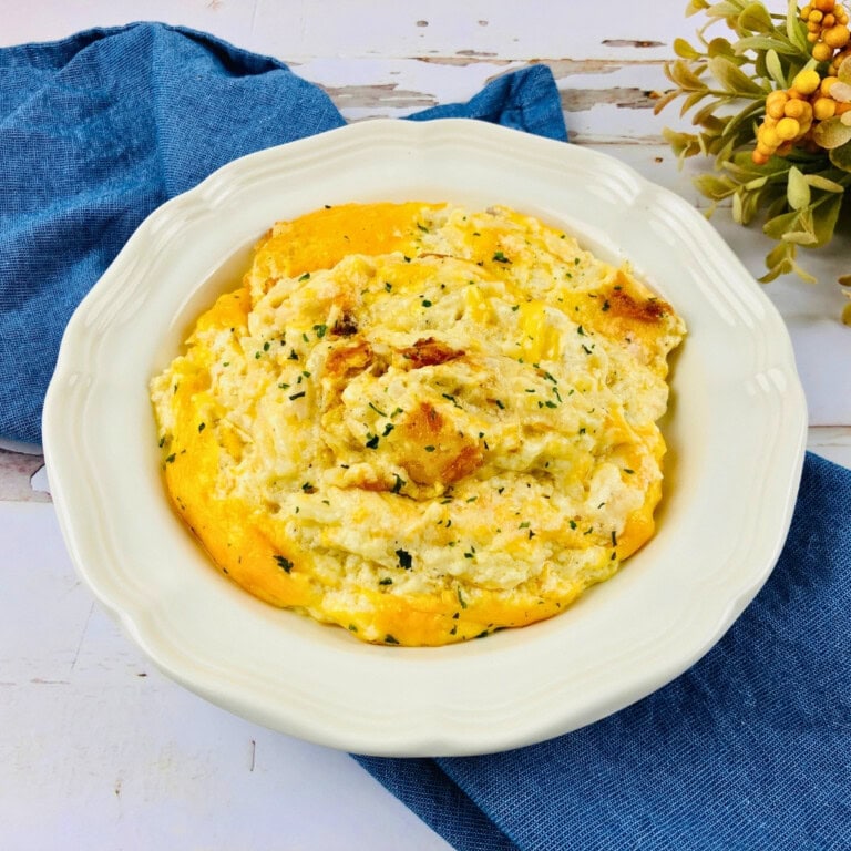A plate of scrambled eggs garnished with herbs, on a blue napkin.