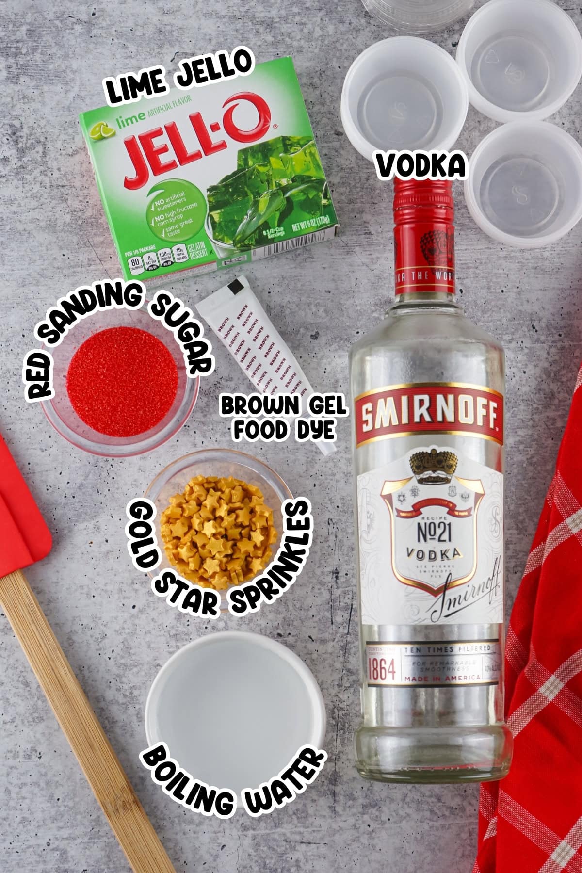 Ingredients for a lime Jello vodka shot recipe arranged on a gray surface.