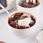 A bowl of Crockpot chocolate cake topped with a scoop of vanilla ice cream.
