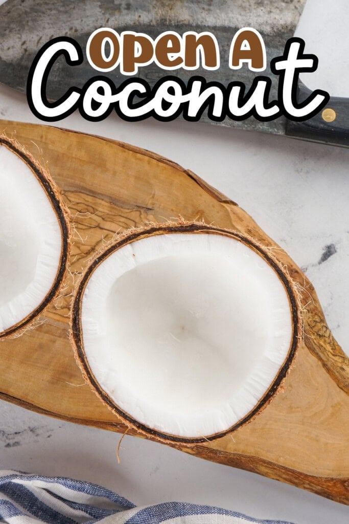 Halved coconut on a wooden board.