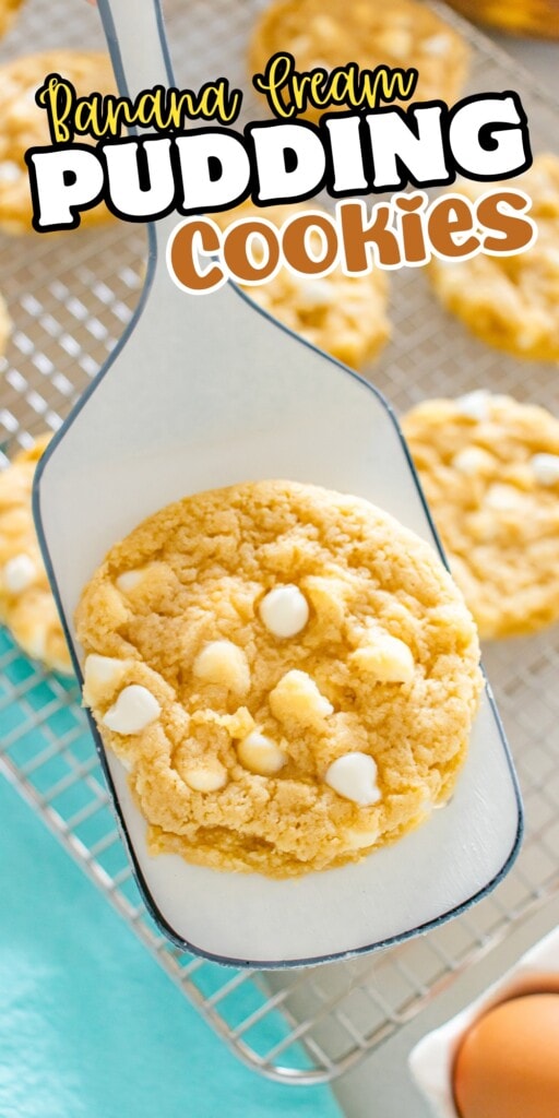 A spatula holding a banana cream pudding cookie with white chocolate chips.