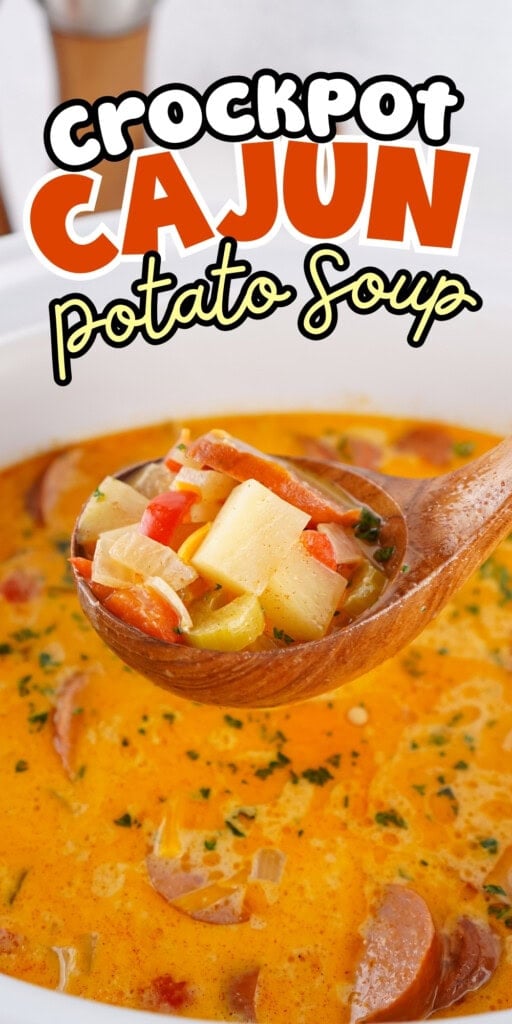 A wooden spoon scoops Cajun potato soup from a white crockpot.