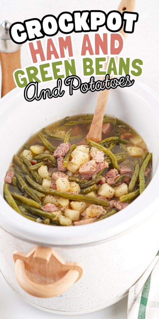 Crockpot of ham, green beans, and potatoes with a wooden spoon.