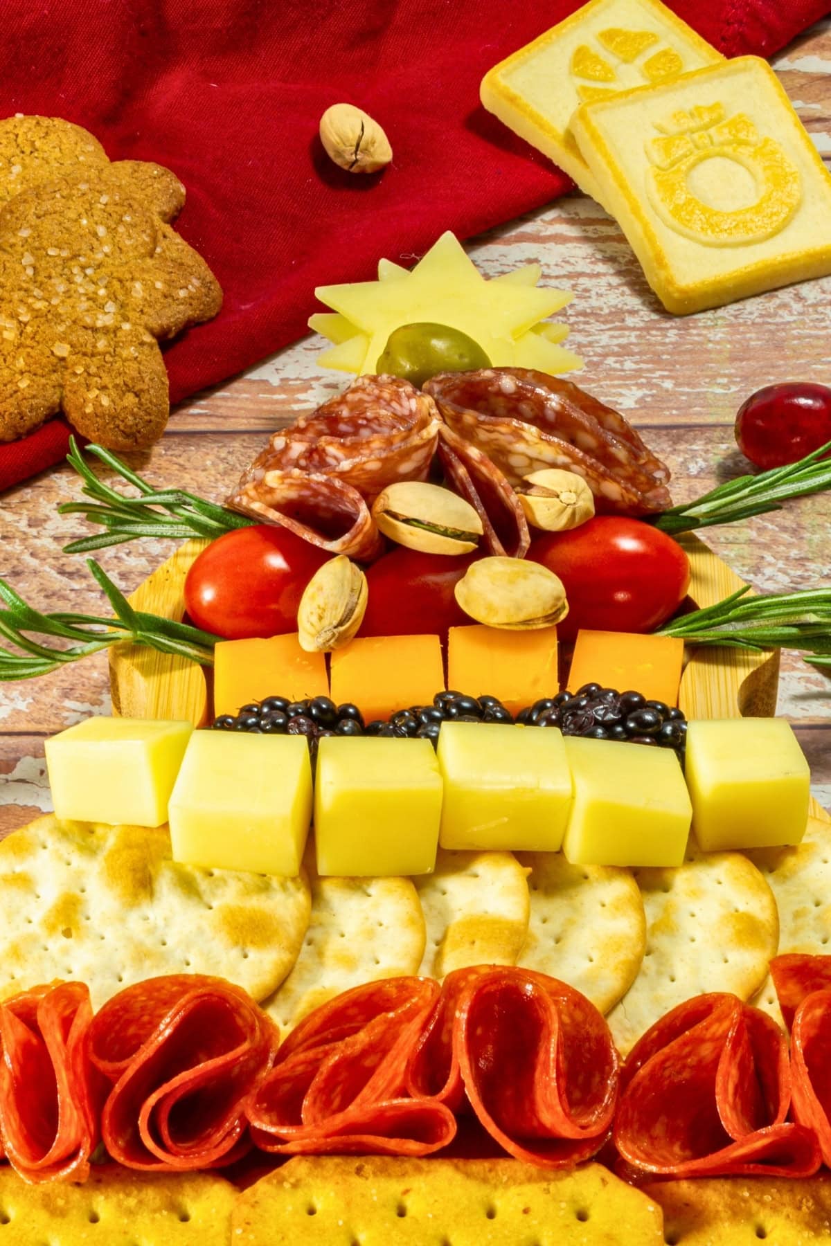 A Christmas tree-shaped charcuterie board with meats, cheeses, and crackers.