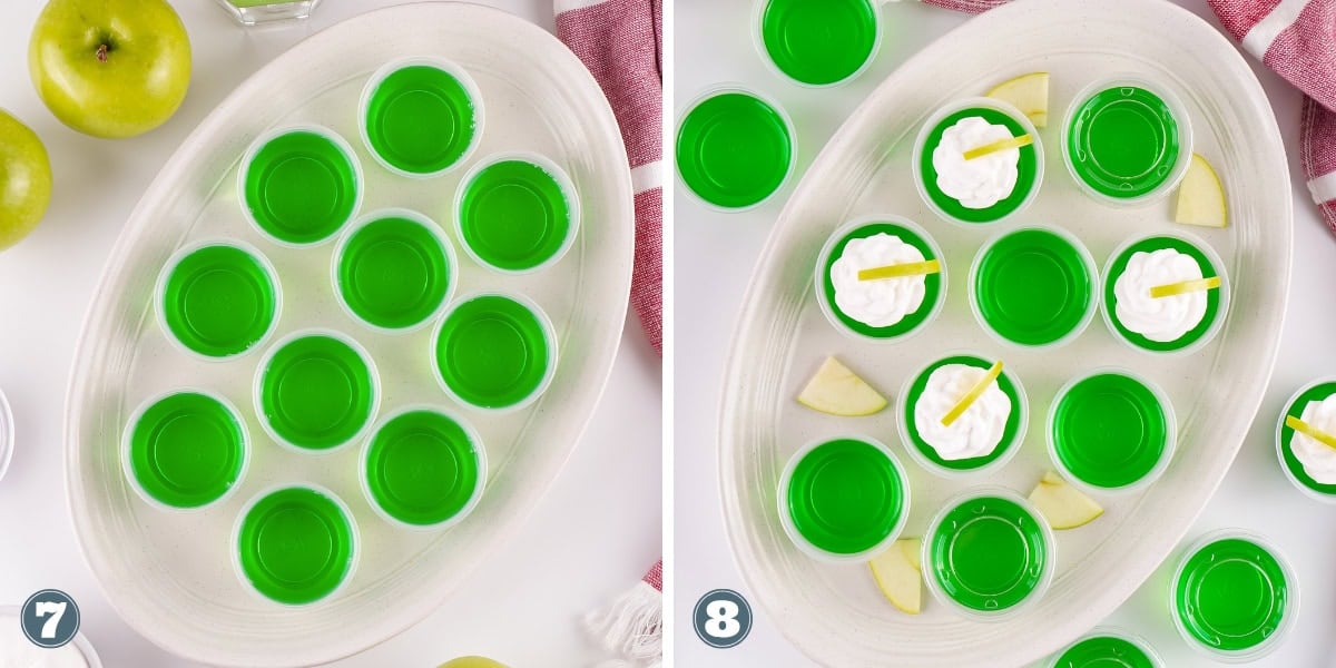 Several green gelatin shots in cups, some topped with cream and apple slices.