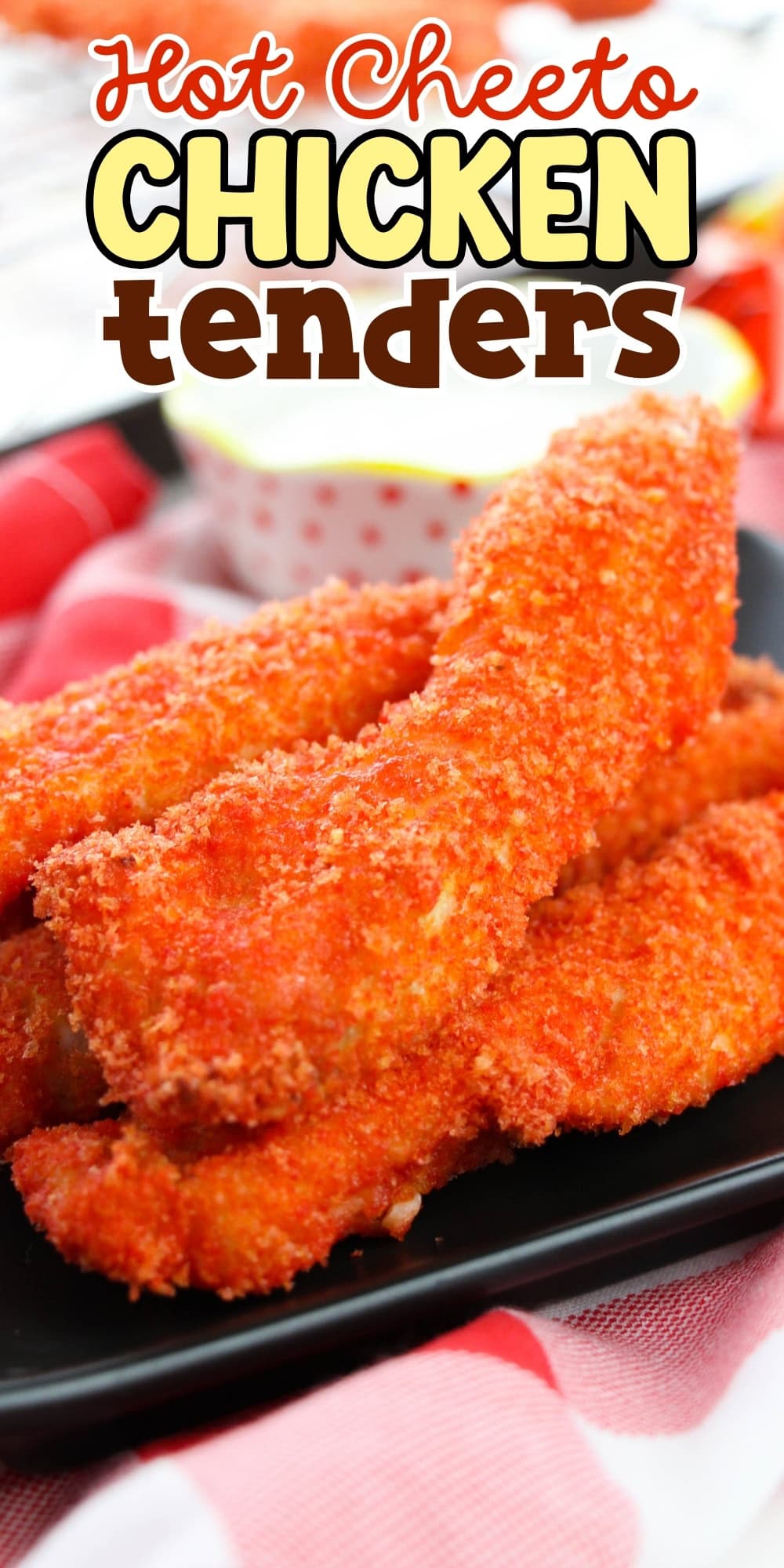 A plate of crispy Hot Cheeto chicken tenders with dipping sauce in the background.
