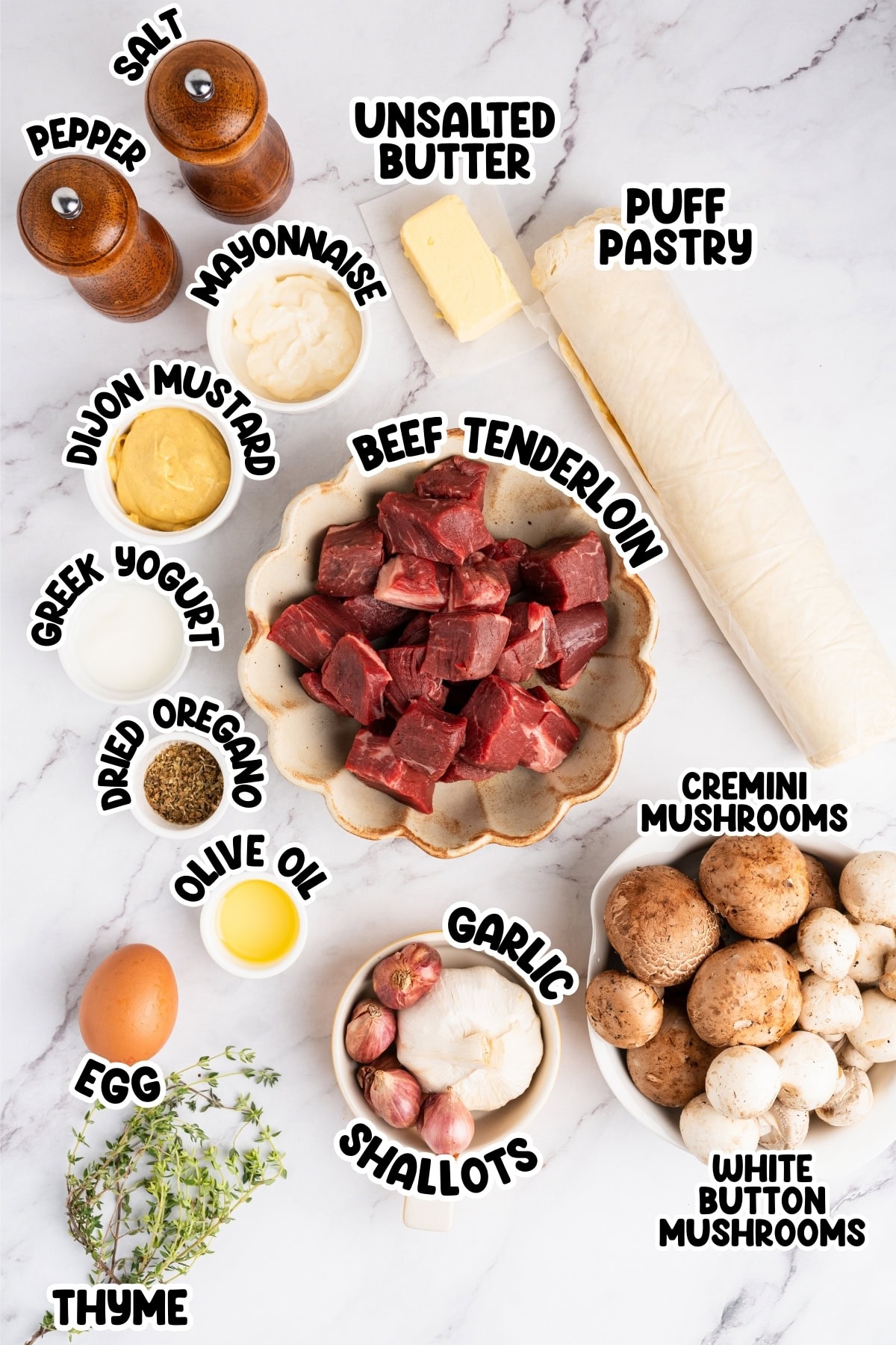 Ingredients for beef Wellington arranged on a white surface.