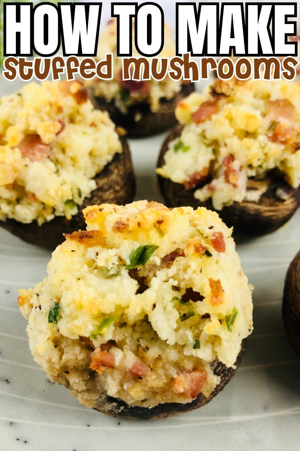 Stuffed mushrooms topped with crispy breadcrumbs on a white plate.