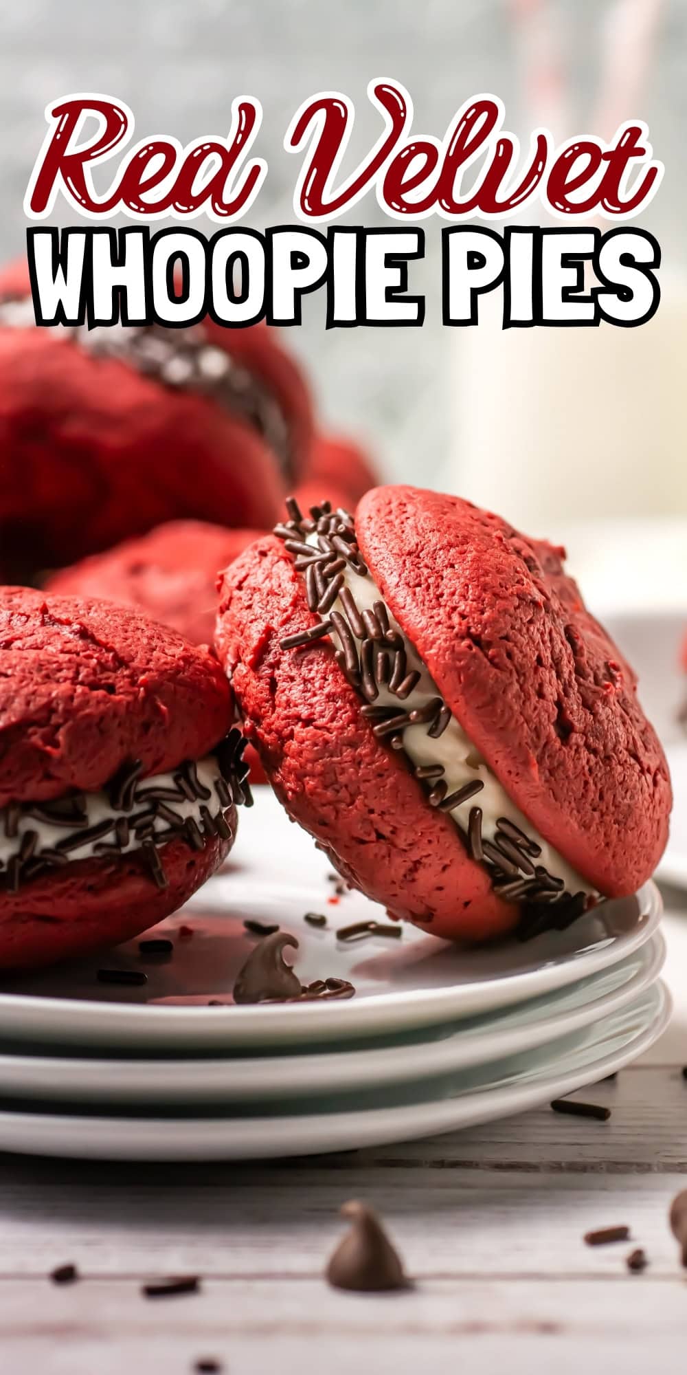 Red velvet whoopie pies with cream filling and chocolate sprinkles on plates.