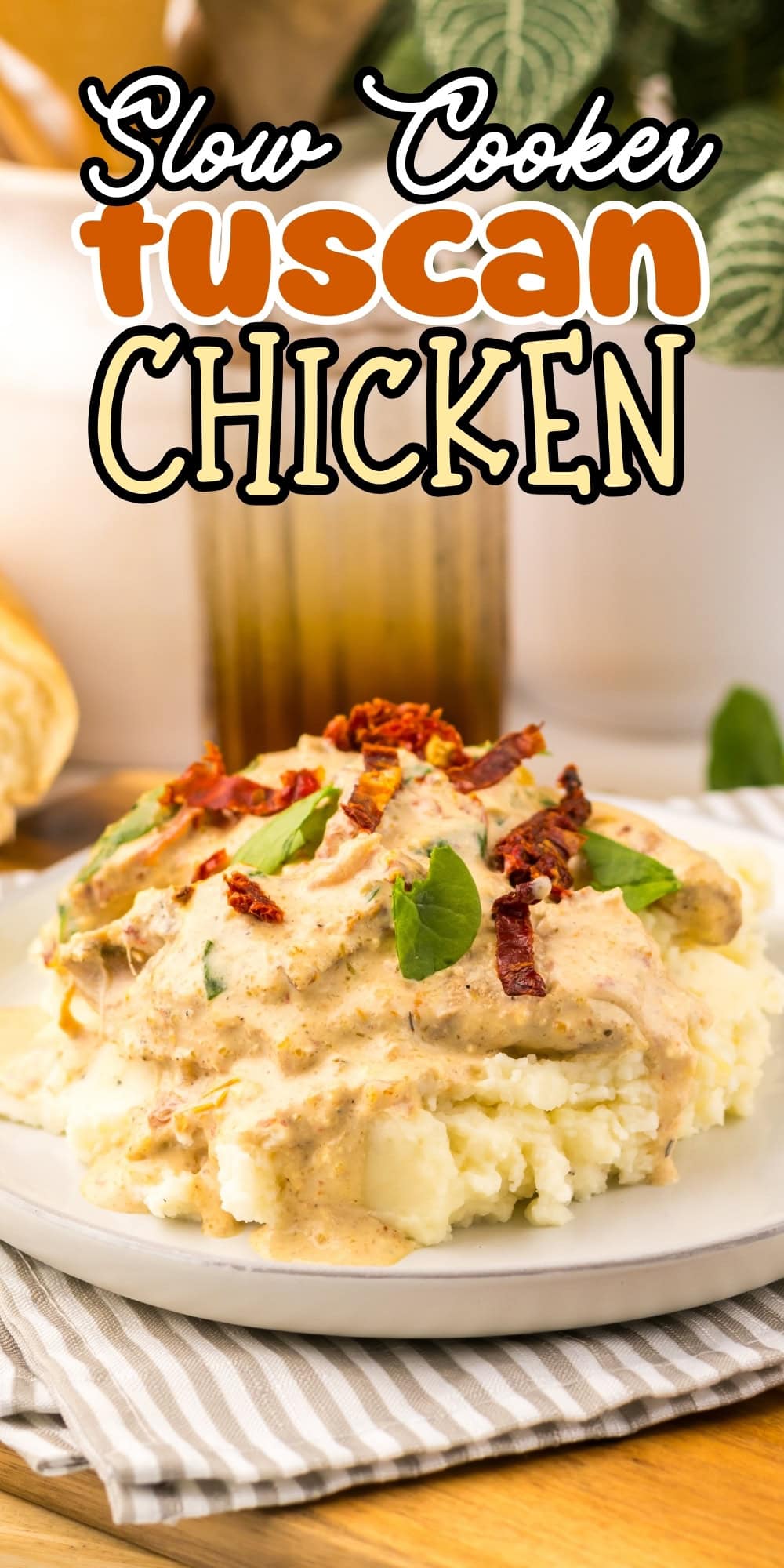 Plate of Tuscan chicken with creamy sauce and herbs over mashed potatoes.
