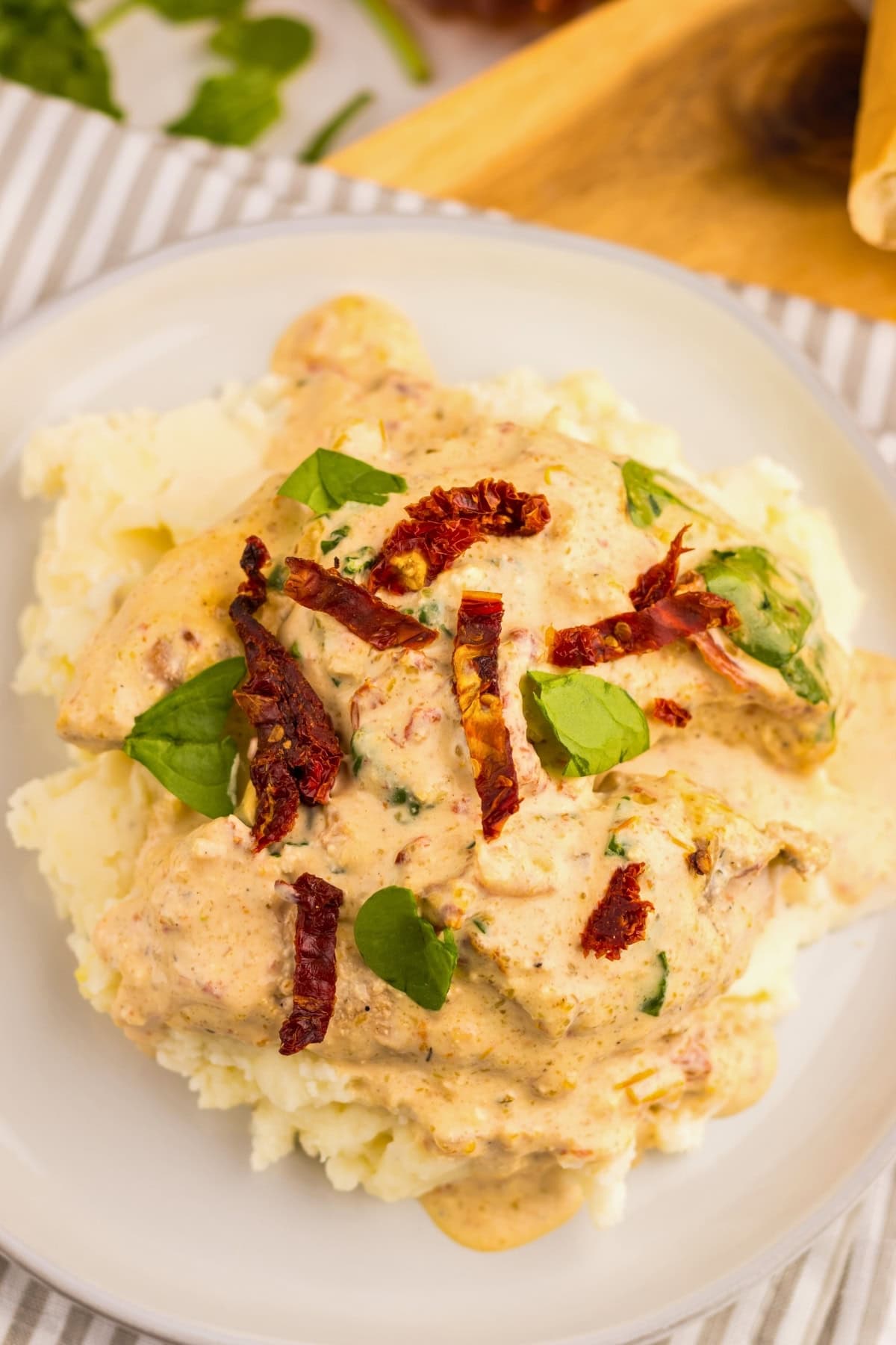 Chicken in creamy sauce with spinach and sun-dried tomatoes over mashed potatoes.