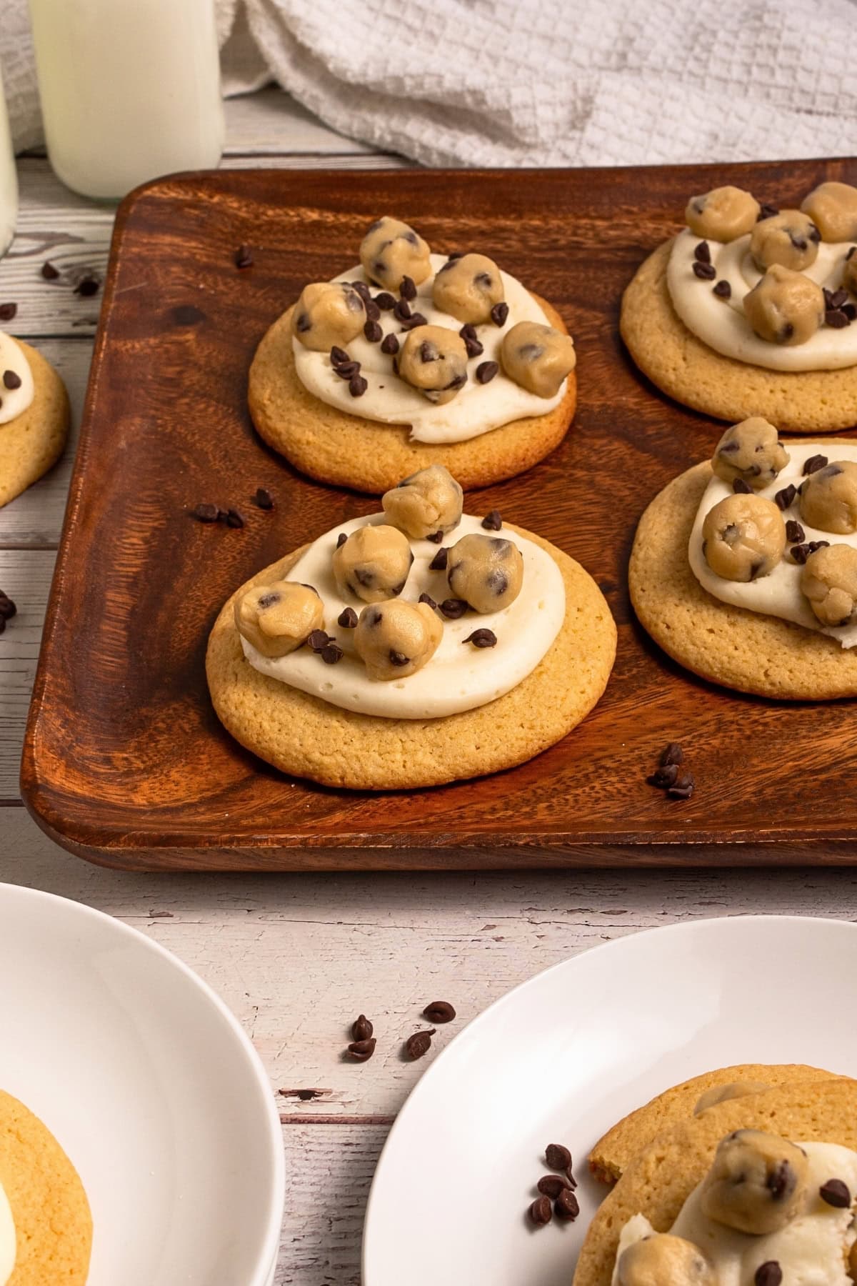Sugar cookies topped with frosting, cookie dough bites, and chocolate chips.