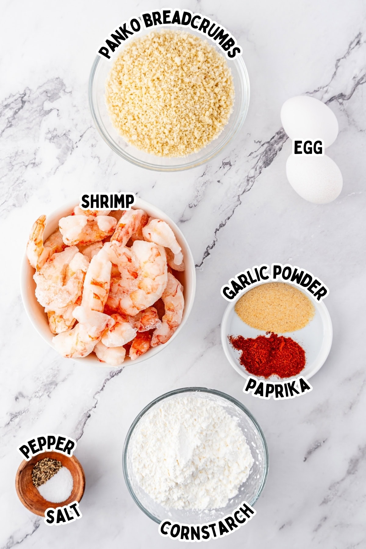 Ingredients for breaded shrimp, including shrimp, eggs, spices, cornstarch, and breadcrumbs.