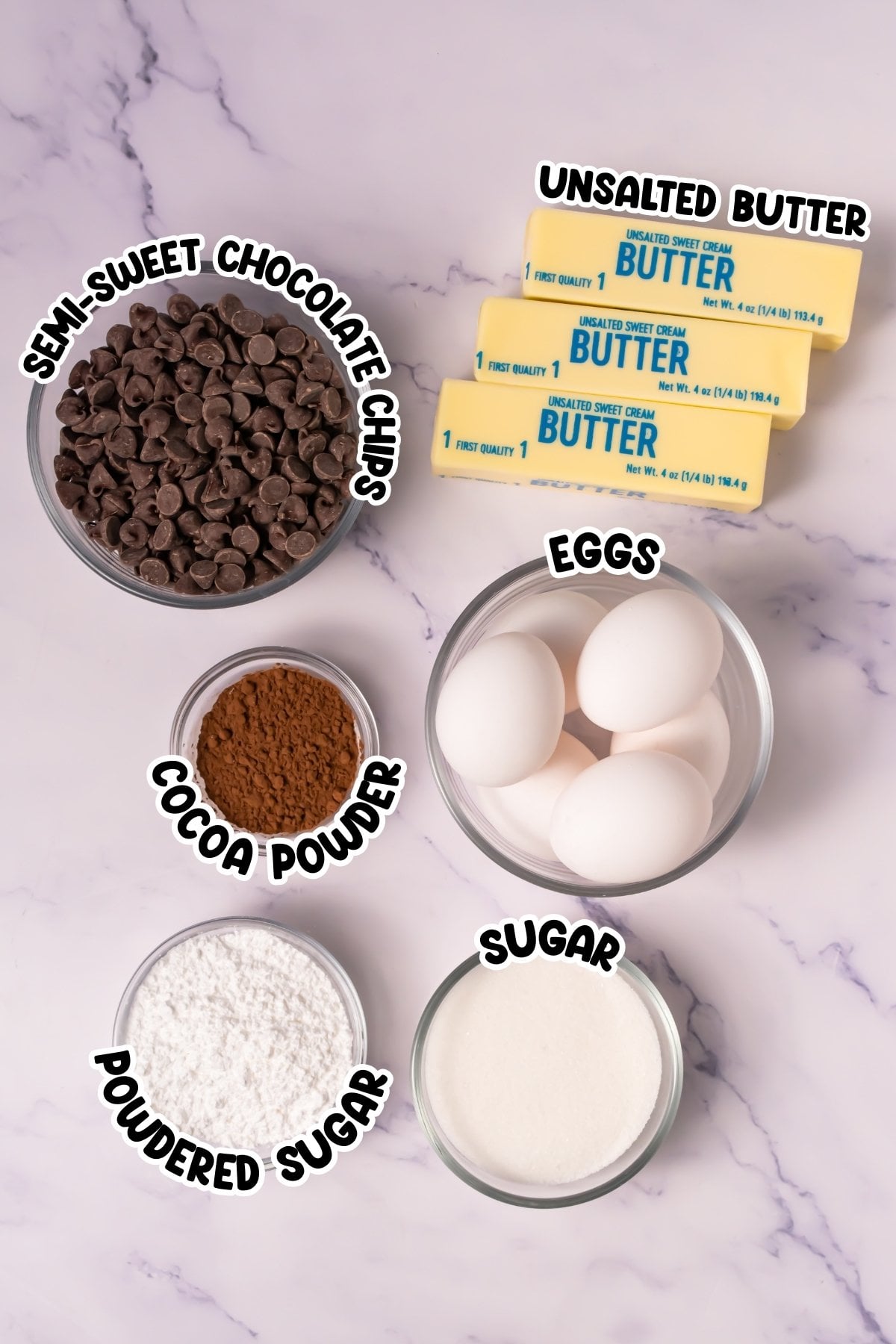 Baking ingredients: butter, eggs, sugar, powdered sugar, cocoa, chocolate chips.