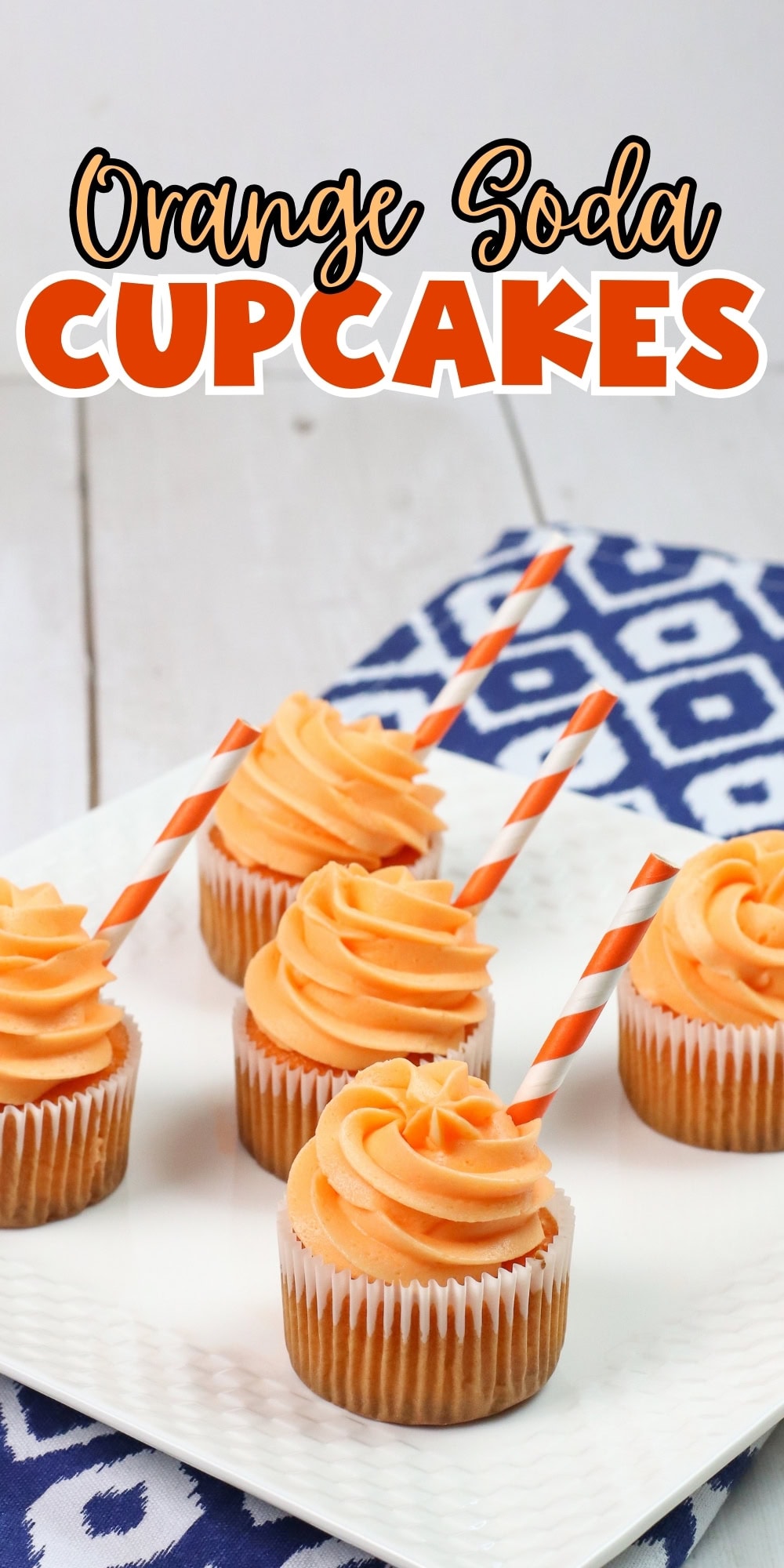 Six orange cupcakes with swirled frosting and striped straws on a white plate.