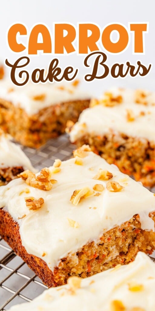 Carrot cake bars with cream cheese frosting and chopped walnuts on a cooling rack.