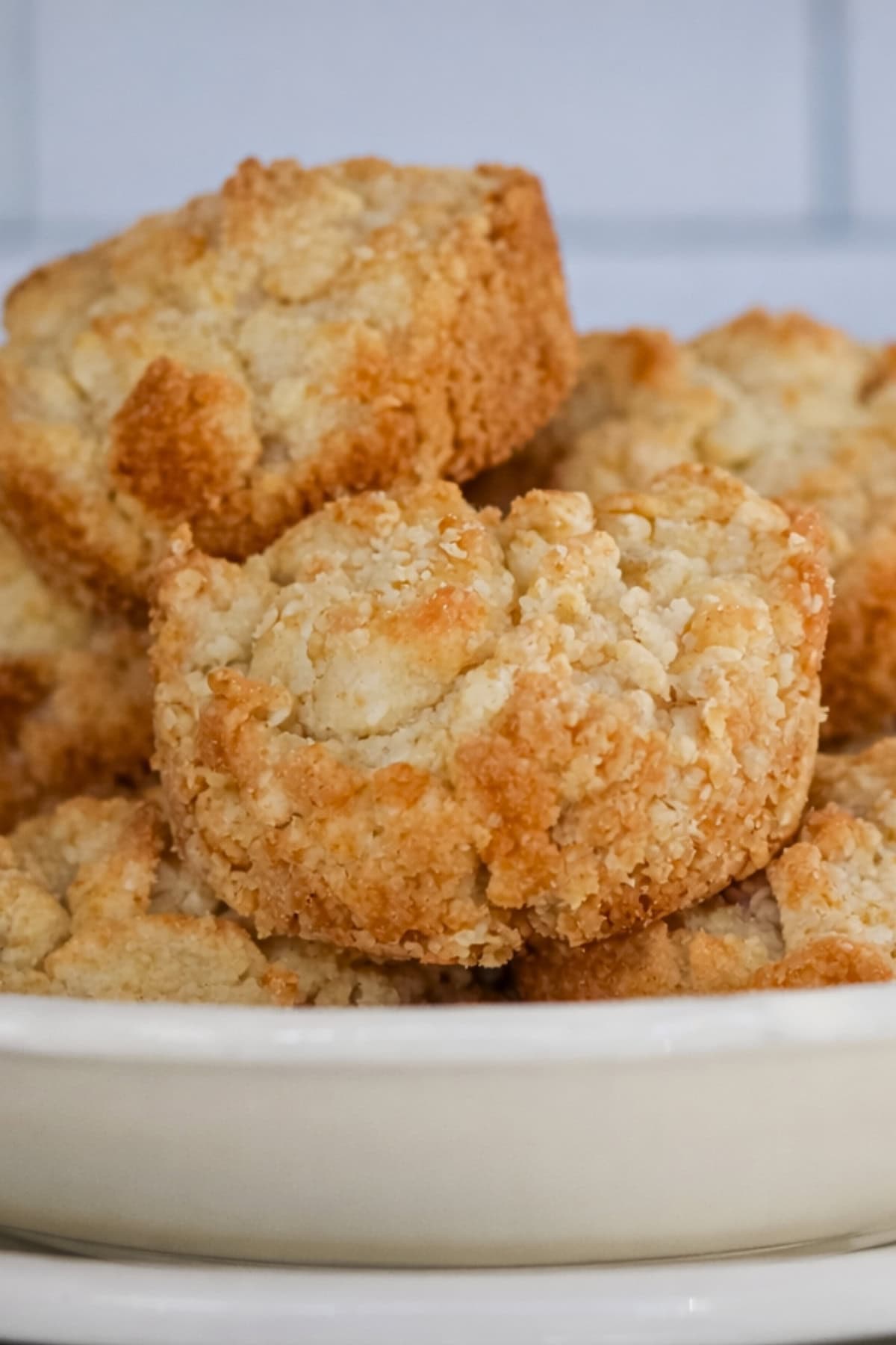 A plate stacked with golden, crumbly biscuits.