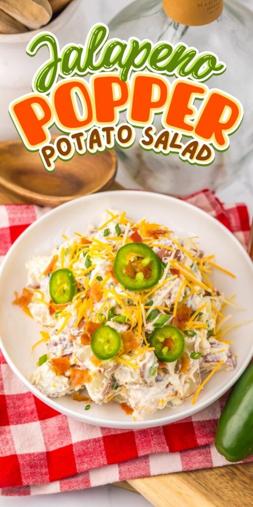 A bowl of jalapeño popper potato salad topped with cheese and jalapeño slices.