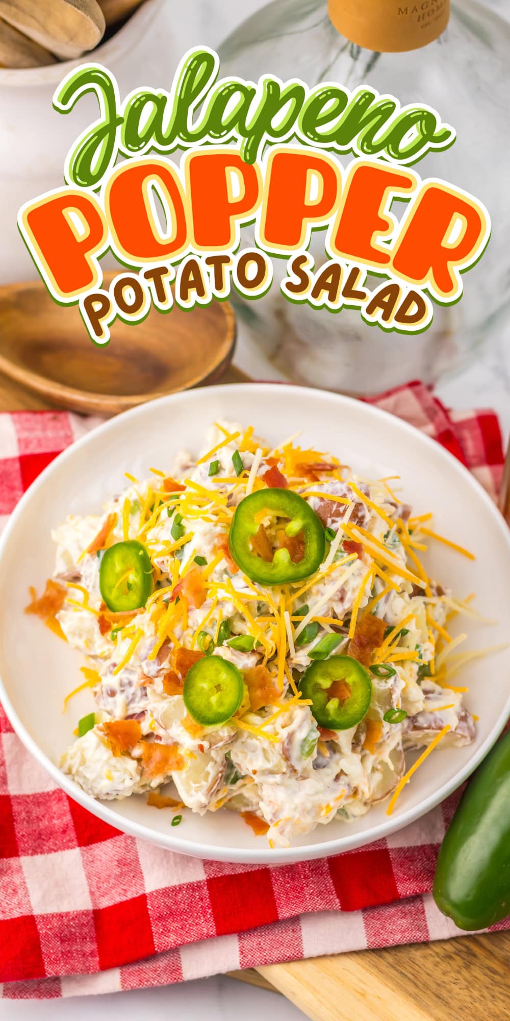 A bowl of jalape&ntilde;o popper potato salad topped with cheese and jalape&ntilde;o slices.