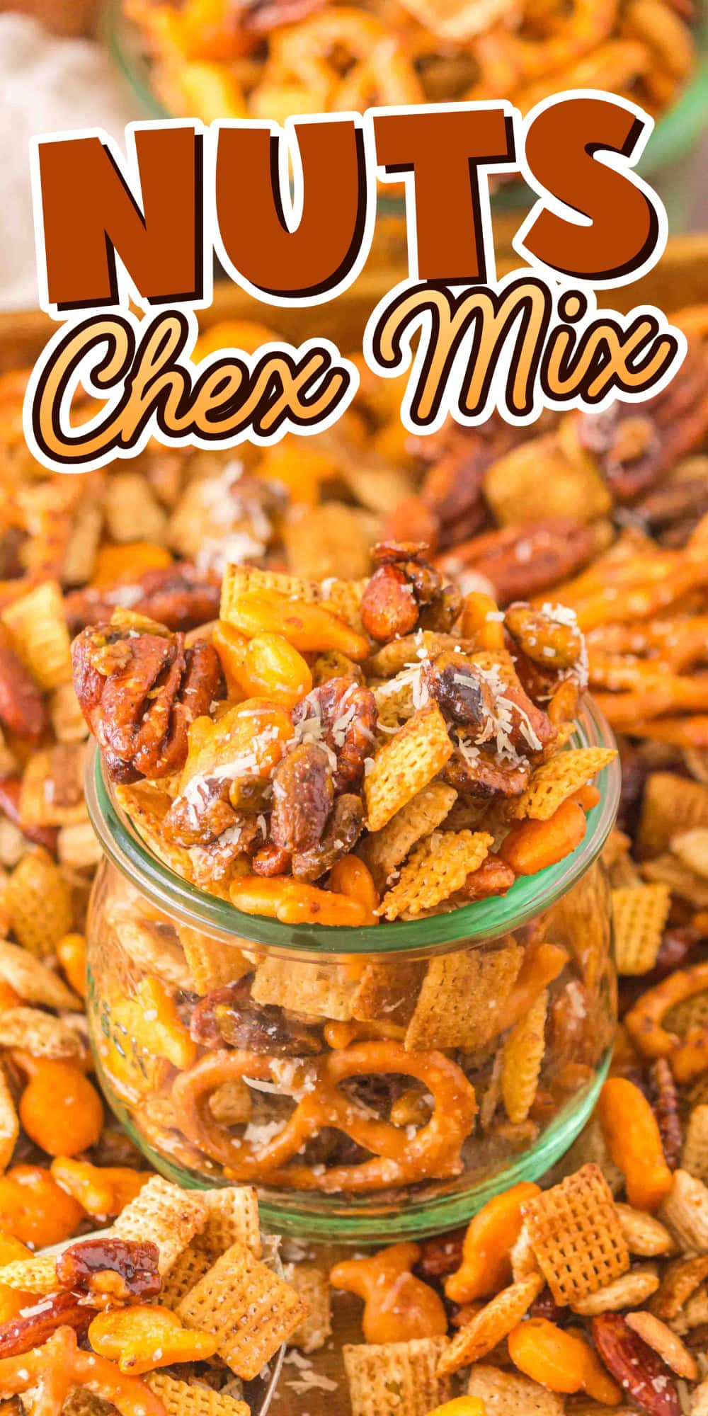 A jar filled with nuts and Chex mix, surrounded by more snack mix.