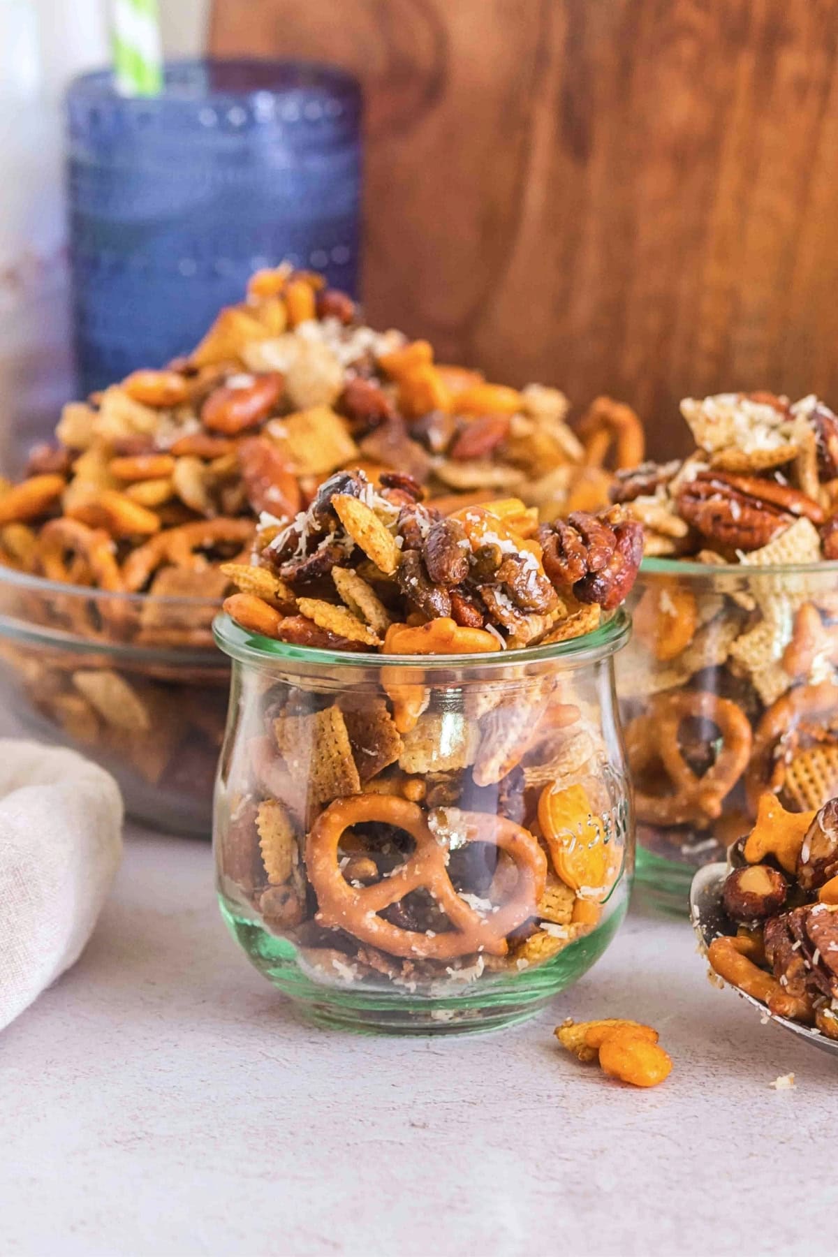 Small glass jars filled with homemade snack mix, including pretzels and nuts.