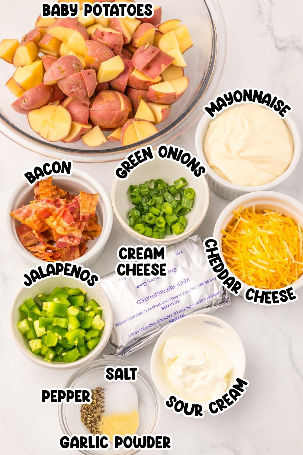 Chopped baby potatoes and bowls of bacon, jalapenos, cheese, cream, and seasonings.
