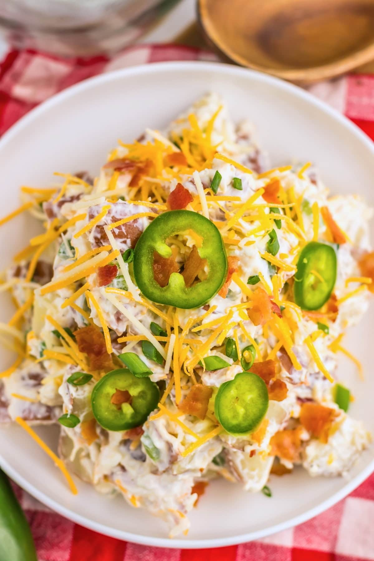 Potato salad topped with shredded cheese, bacon, scallions, and jalape&ntilde;o slices.