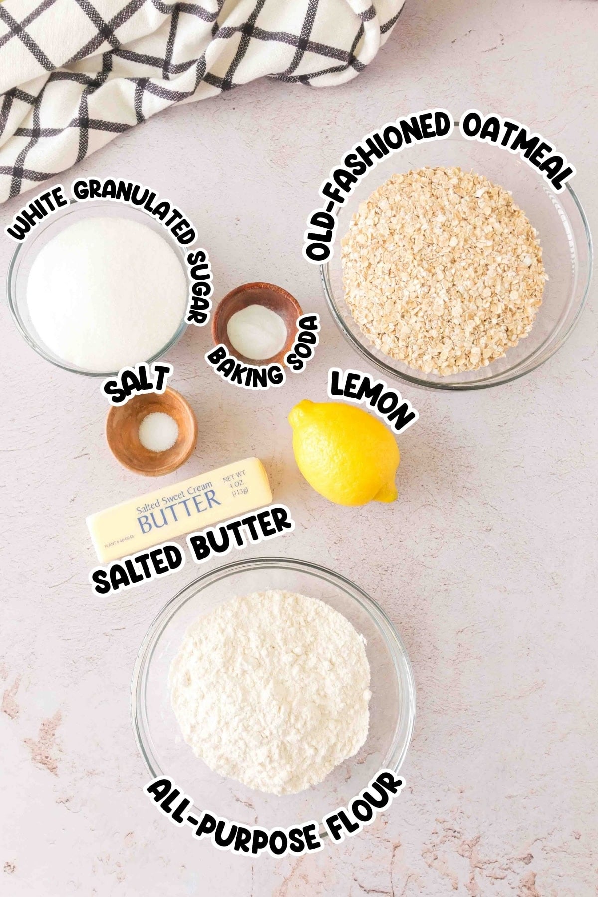 Baking ingredients: sugar, oatmeal, salt, baking soda, lemon, butter, flour.