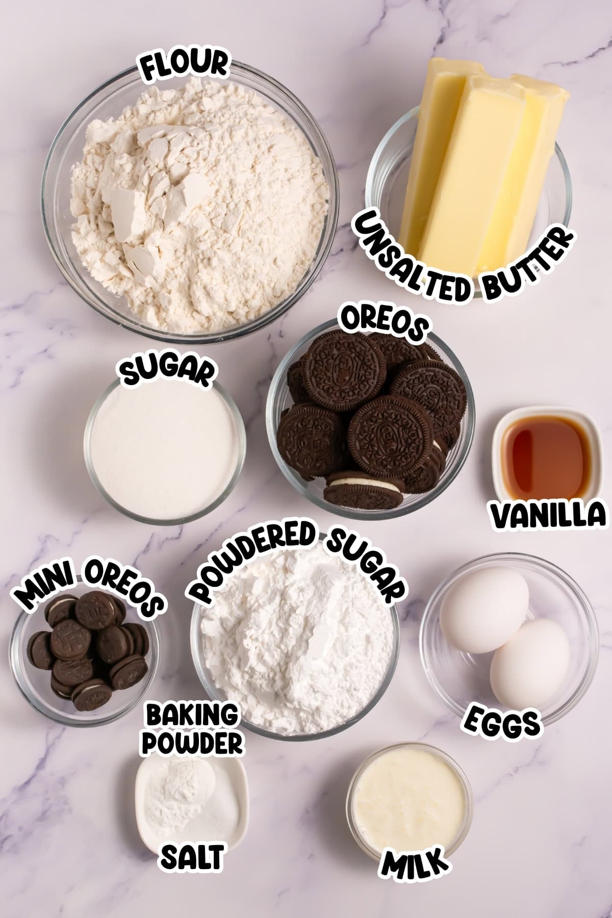 Baking ingredients in bowls, including flour, butter, sugar, Oreos, eggs, and milk.