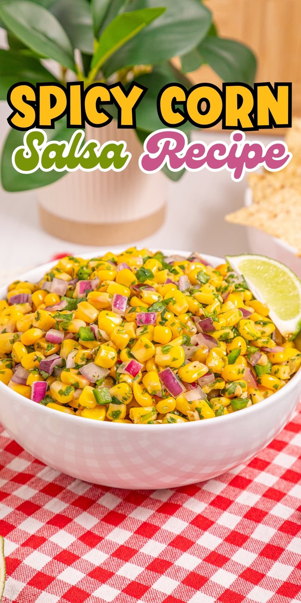 A bowl of spicy corn salsa with diced onions and herbs, garnished with lime.