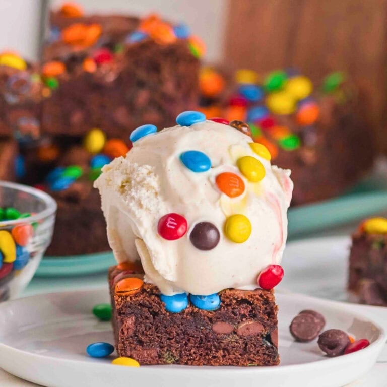 A brownie topped with vanilla ice cream and colorful chocolate candies.