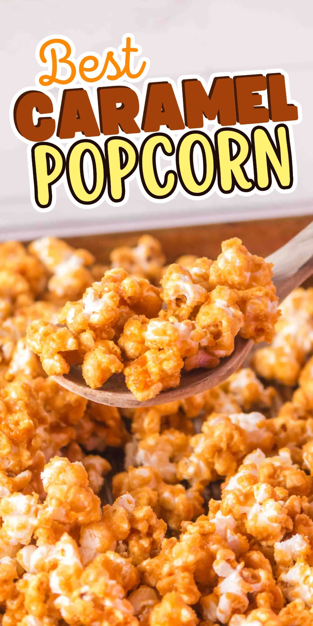 A wooden spoon scoops caramel popcorn.