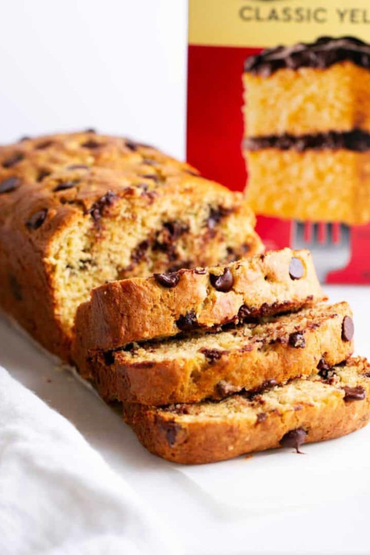 Sliced loaf of chocolate chip bread with a cake mix box in the background.