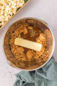 Butter, brown sugar, and syrup in a mixing bowl, with popcorn nearby.